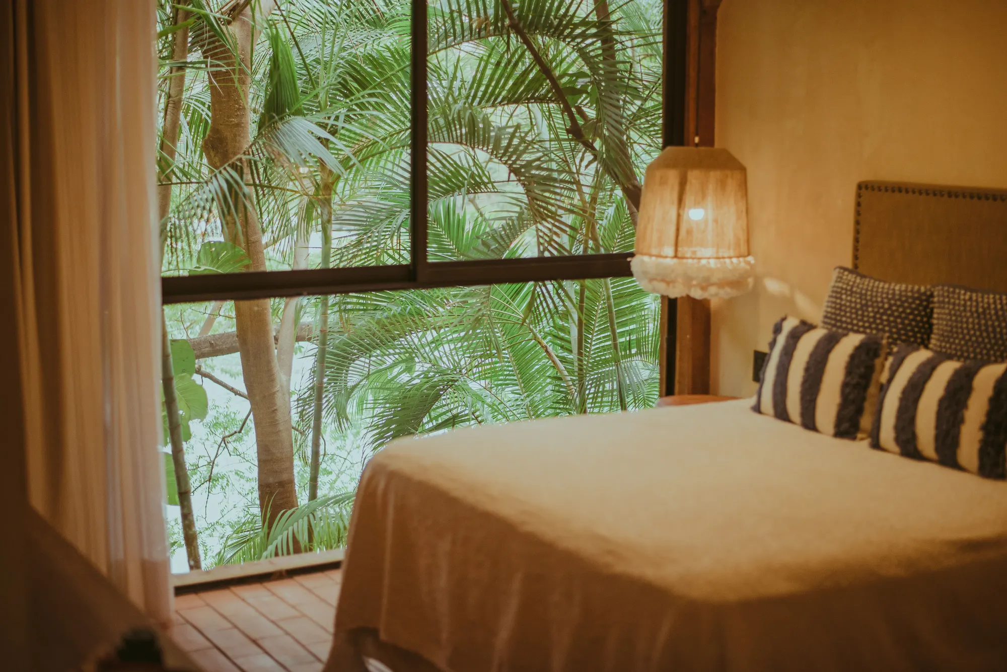 A guest room with the bed made and a window onto the view