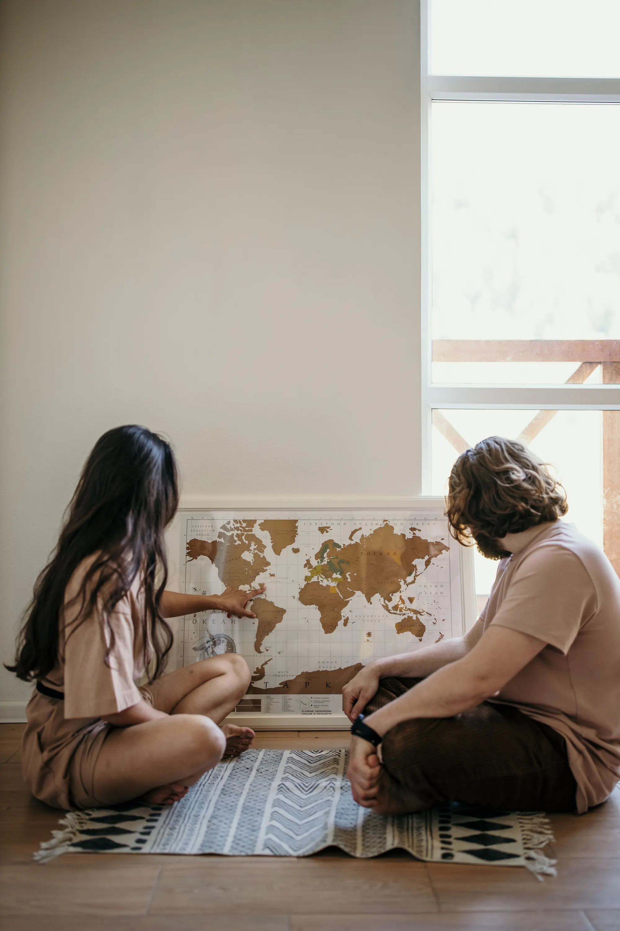Travelers comparing destinations while planning a trip with a world map